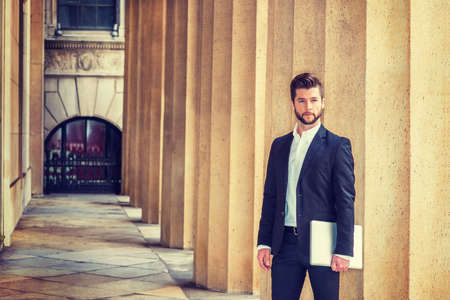 American businessman with beard working in New York, wearing black suit, white shirt, arm carrying...
