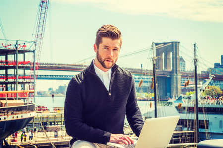 American businessman with beard traveling, working in New York, wearing black sweater, tan pants,...