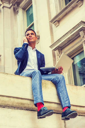African American college student studies in New York. Wearing blue blazer, gray pants, white shirt,...