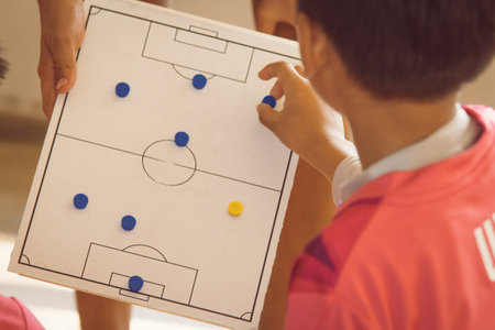 Children playing table football at school. Focus on the table football.