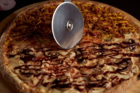 A special pizza knife cuts it into pieces. closeup photoの写真素材