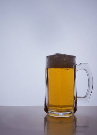 silhouette of a beer mug with amber yellow beer, which is poured with foam. Hight quality photoの写真素材