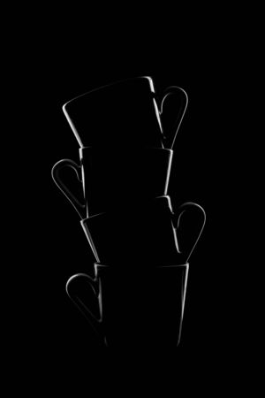 Silhouettes of small coffee cups on a black background. Beautiful shape. High quality photoの写真素材