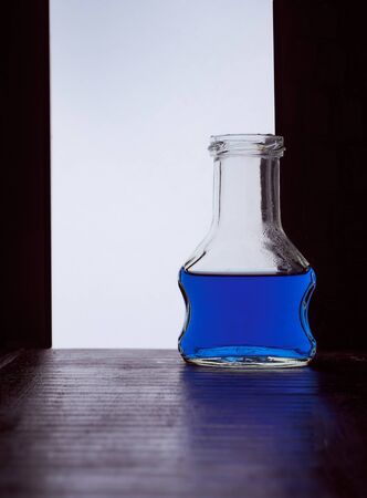 chocolate cream bottle on a black white background with blue liquid . Hight quality photoの写真素材