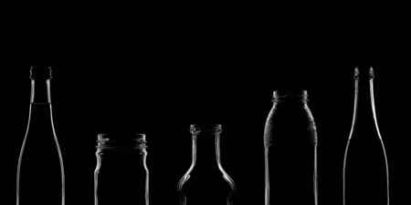 The silhouettes of bottles with various beautiful shapes on a black background. Banner for advertising with a place to insert text. High quality photoの写真素材