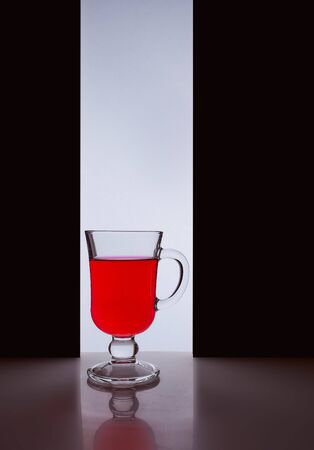 red glass with red liquid on a black white background. Stylish photo. Hight quality photoの写真素材