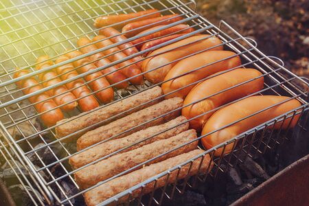 meat sausages, giwapchichi and sausages lie on the iron grill sun flareの写真素材