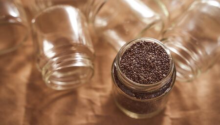 Glass jars. In one of which are the seeds of Chia. promotional photo . High quality photoの写真素材