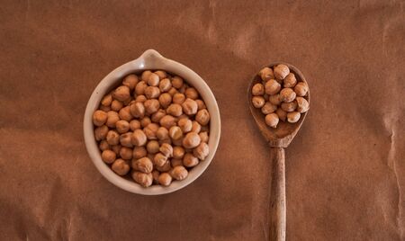 chick lies in a white mortar with a wooden spoon on a brown background. High quality photoの写真素材