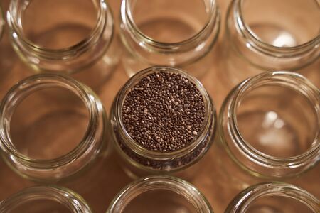 Glass jars. In one of which are the seeds of Chia. promotional photo . High quality photoの写真素材