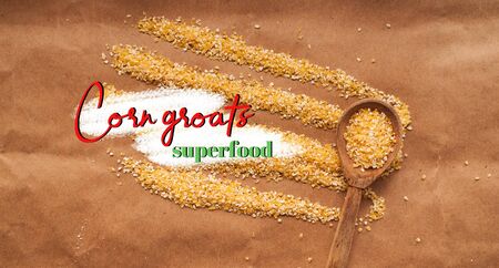Corn grits scattered on a cherrymeal background with a wooden spoon. High quality photo