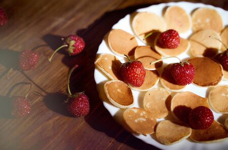Ripe strawberries lie on a white plate. dark wooden table. With copy space. Top view. High quality photoの写真素材