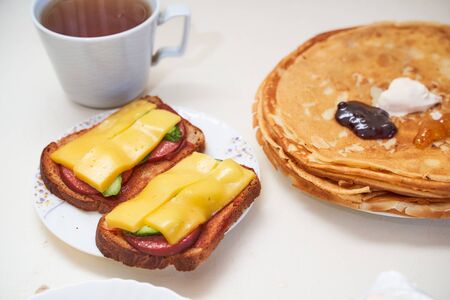 Homemade pancakes with a cup of tea on a light table. High quality photoの写真素材