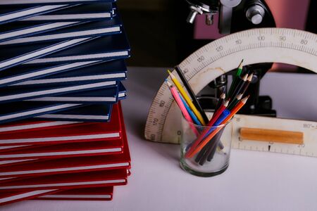 concept of red and blue books which lie on top of each other. Multicolored pencils and school...
