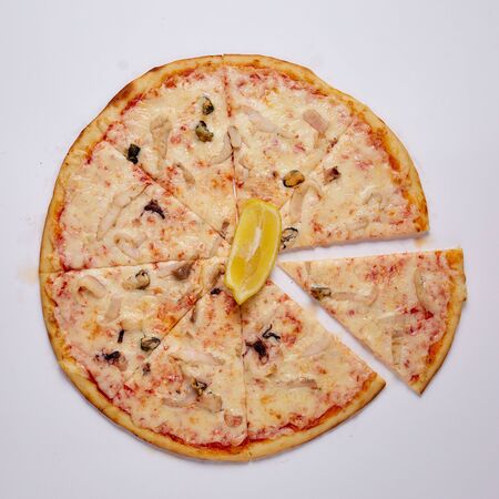 Pizza with cut off slice on a white background. Top view. High quality photo
