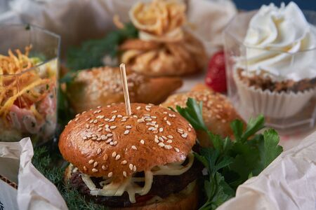 Juicy burger with onion rings, jalapeno pepper, cucumbers, lettuce, cheese on a white background. High quality photoの写真素材