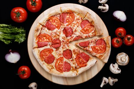 Pizza with ingredients on a black background. High quality photoの写真素材