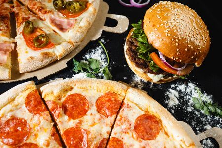 Pizza and burger on a black background. Top view. High quality photoの写真素材