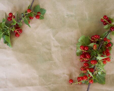 The red currant lies on brown paper. High quality photo