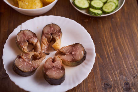 pieces of sardine in a plate on a brown table. High quality photoの写真素材