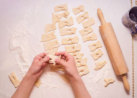 Women's hands form a variety of shapes from the dough. High quality photoの写真素材