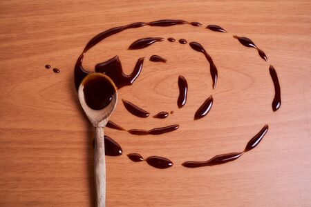 Honey in a wooden spoon. Drops of honey on a wooden background. High quality photoの写真素材