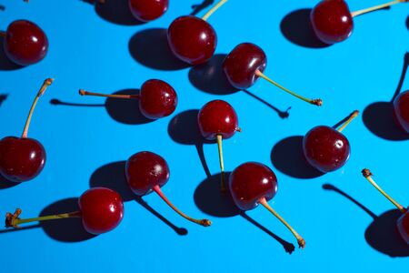 cherry on blue background with shadows. High quality photo