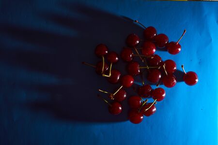 cherry on blue background with shadows. High quality photo