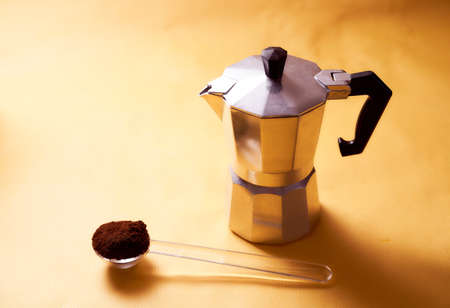 geyser coffee maker with fresh coffee and spoon on a yellow backgroundの写真素材