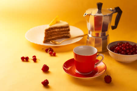 Red cup of coffee and a geyser coffee on a yellow background. With copy space. High quality photoの写真素材