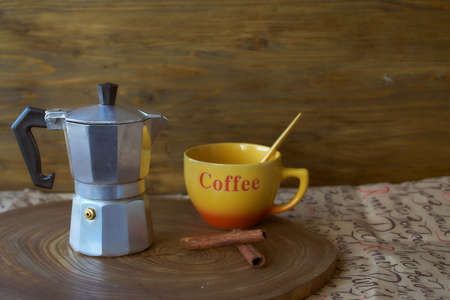 Geyser coffee maker on a wooden tray. Theres a cup of coffee next to it. Dark background. With copy space.の写真素材