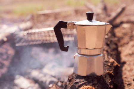 Geyser coffee maker stands on a wooden board against smoke background. With copy space. With copy space. High quality photoの写真素材