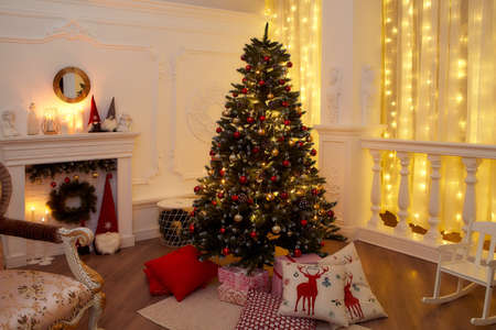 New Years interior with Christmas tree, fireplace, pillows. Very beautiful evening photo for Christmas