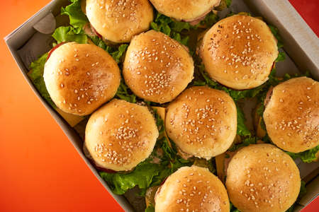 Mini cheeseburgers are in a paper box. Set for a picnic. High quality photoの写真素材