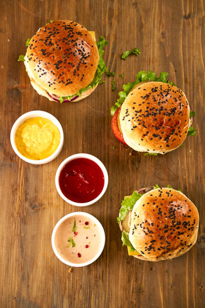 Burgers on a wooden background with sauces. Top view. High quality photoの写真素材