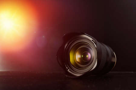 Stylish photo lens with beautiful glare on a black background. With copy space. High quality photo