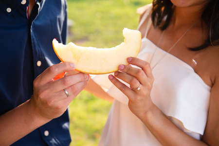man and woman holding ripe yellow melon. High quality photo