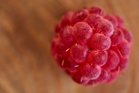 Red ripe raspberries in macro mode. Brown wooden background. High quality photo