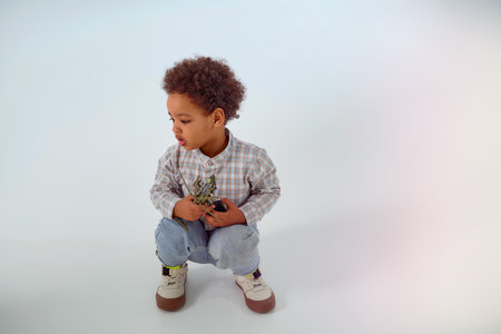 Little African-American boy sits with toy helicopter on white background. high quality photo