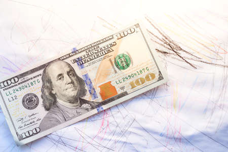 One hundred dollar notebook on an inscribed white paper background