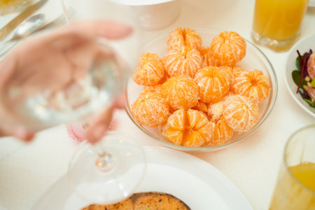 Delicious peeled tangerine slices lie in a transparent plate with dessertsの写真素材