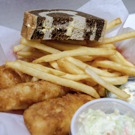 Bar Food:  Typical Friday night fish fry in Wisconsin.  Fried cod, french fries, coleslaw, tartar sauce and marbled rye bread in a basket.の写真素材