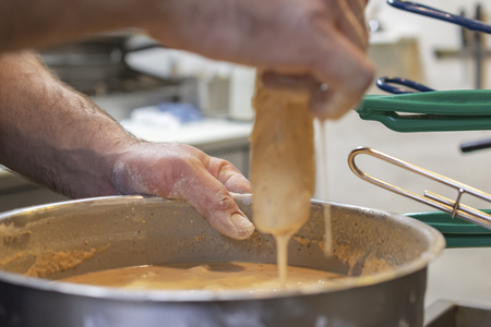 Chef preparing a typical Friday night fish fry in Wisconsin.  Dipping fish fillets in beer batter before dropping them into a hot fryer.の写真素材