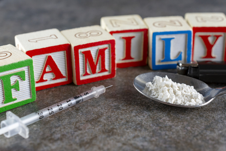 syringe and spoon with powder depicting drug use with the word family in blocksの写真素材