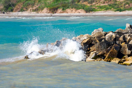 A wave crashes into the break wall at Coral Dock Park in Port Washington, Wisconsin.の写真素材