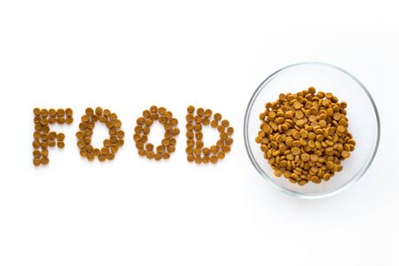 Word FOOD mark made of dry food with full bowl. Pet care and veterinary concept with letters on white background.の写真素材
