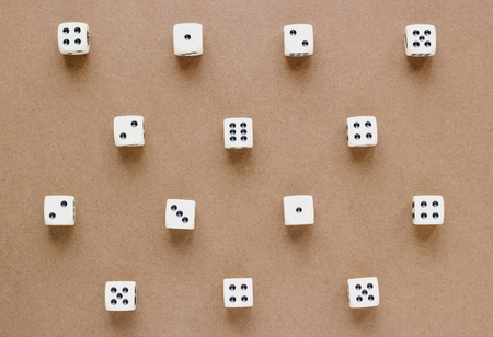 Gaming white dice pattern on brown background in flat lay style. Concept with copy space for games,...