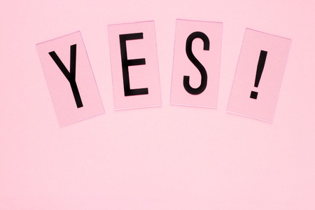 YES word plastic letters with copy space on pink background. Pastel concept for web, presentation, banners or motivation. Top view image.の写真素材