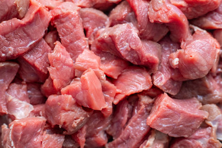Close up of raw meat. The meat is cut into small pieces. The meat is red in color. Chopped pieces of beef for cooking. Fresh ingredients for marinating and barbecueの写真素材