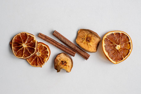 Bouquet of dried fruits with cinnamon on a white background. Slices of orange and cinnamon sticks. Sliced pieces of citrus with spices for aromatherapy tea and New Years decorの写真素材